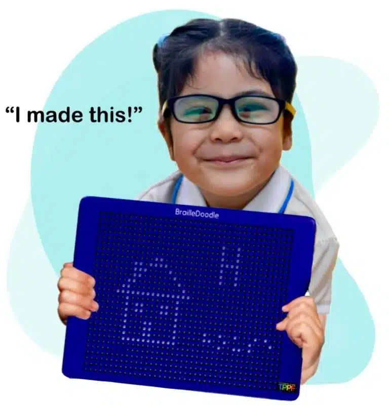 young girl smilins and holding brailledoodle